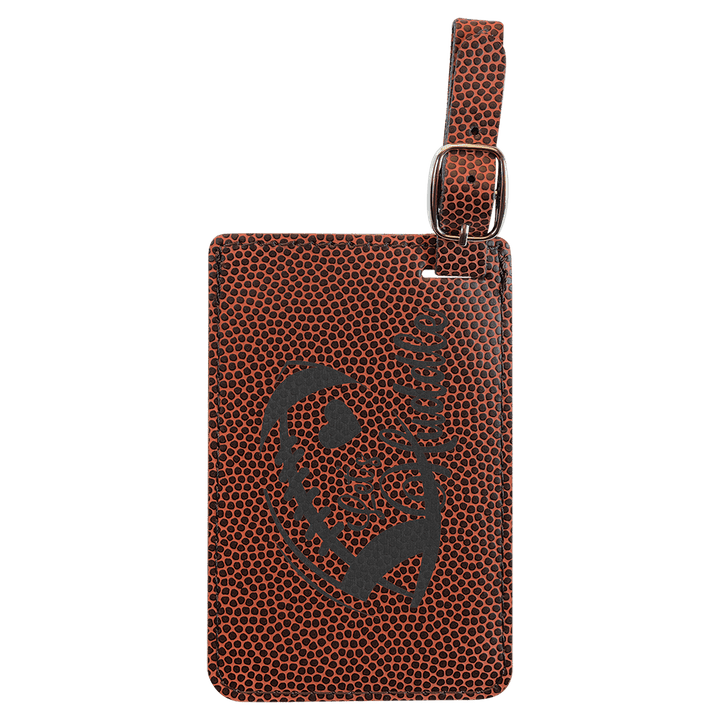Brown pebbled leather luggage tag with gray skull design and metal buckle attachment loop.