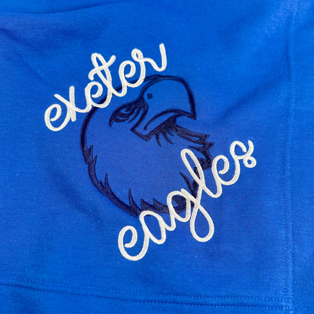 Royal blue fleece blanket with embroidered Exeter Eagles eagle mascot logo and white script text.