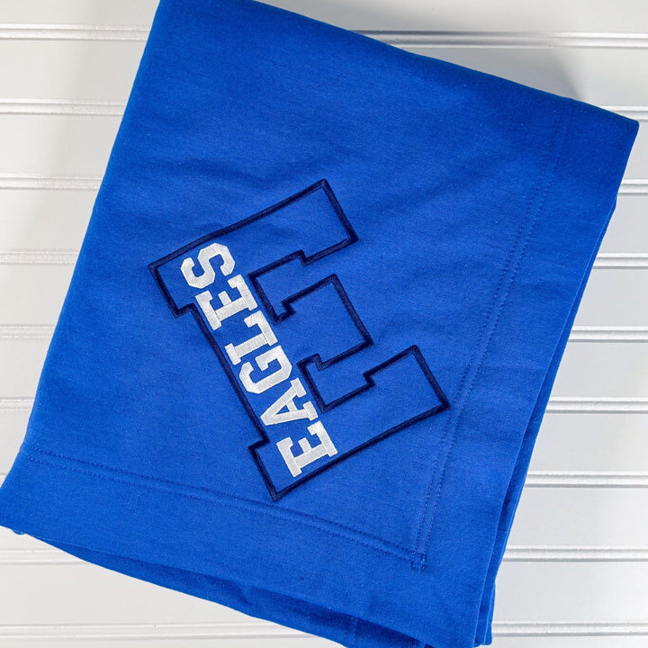 Royal blue fleece blanket with embroidered Exeter Eagles varsity letter logo and three striped boxes design