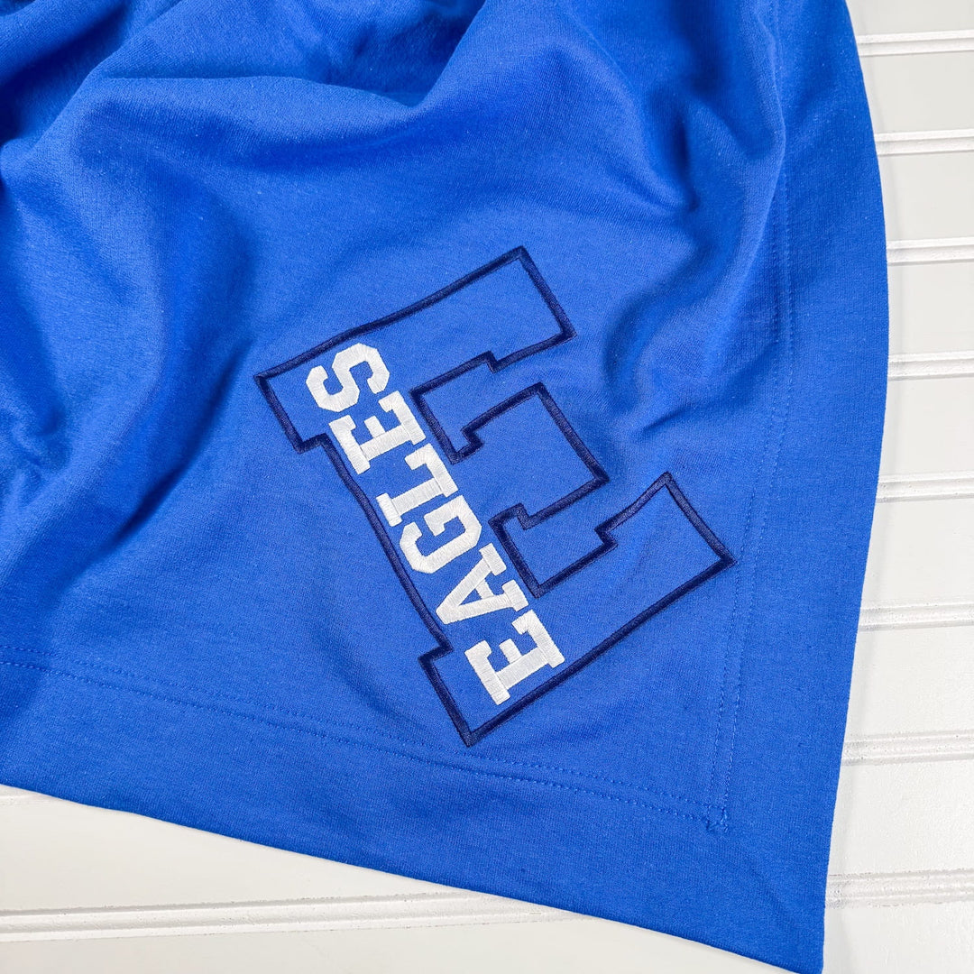 Royal blue fleece blanket with embroidered Exeter Eagles varsity letter design in white and navy outline.