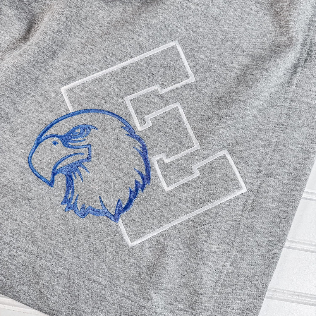 Gray fleece blanket with blue embroidered eagle mascot head and white varsity letter E patches.