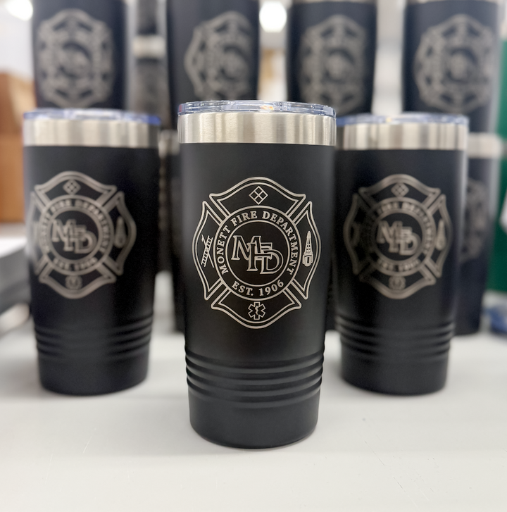 Black stainless steel tumblers with fire department badge laser engraved on front, displayed in rows.