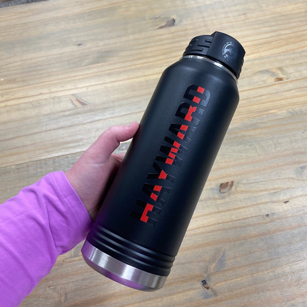 Black insulated water bottle with red thin line design and stainless steel base, held in hand against wooden surface.