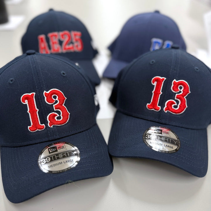 Navy New Era stretch fit cap with a red and white embroidered fire department number, factory size sticker still applied