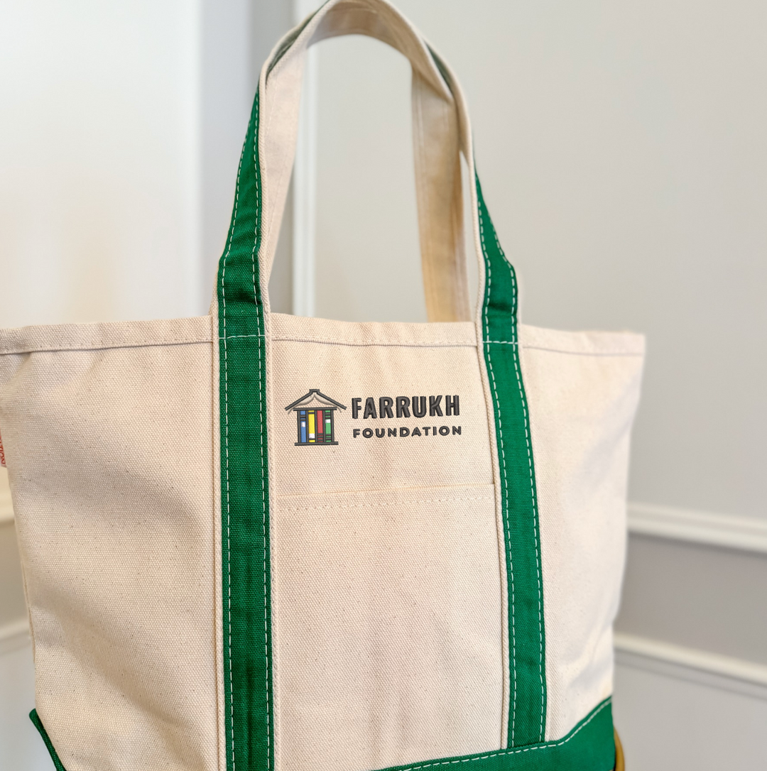 Natural canvas tote bag with green handles and Farrukh Foundation logo embroidered on front pocket.