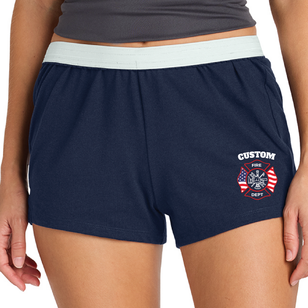 Woman wearing navy firefighter wife shorts with white waistband and a personalized American flag Maltese "Custom Fire Dept" design printed on the left leg, front view.