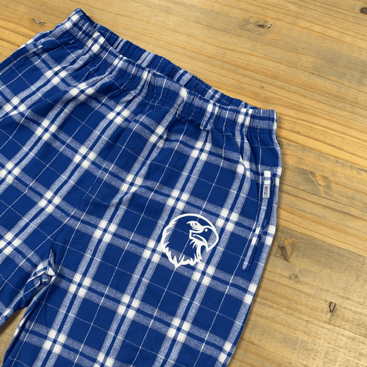 Blue and white plaid flannel pants with embroidered eagle head logo on thigh