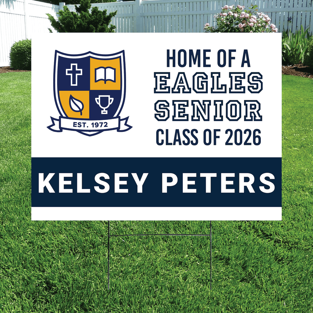 White yard sign with blue and gold Eagles crest logo, "Home of a Eagles Senior Class of 2026" text, and personalized name "Kelsey Peters" on dark blue band.