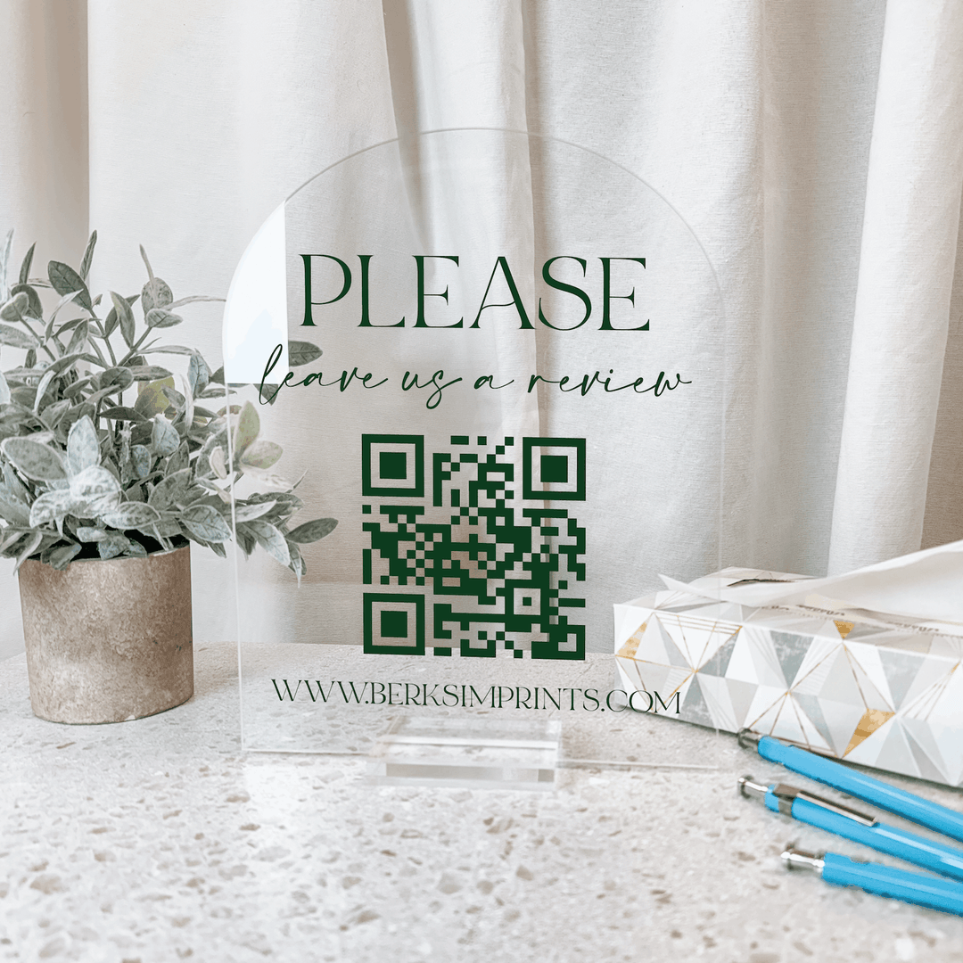 Clear acrylic sign with "PLEASE leave a review" text and green QR code, featuring www.berksimprints.com website URL.