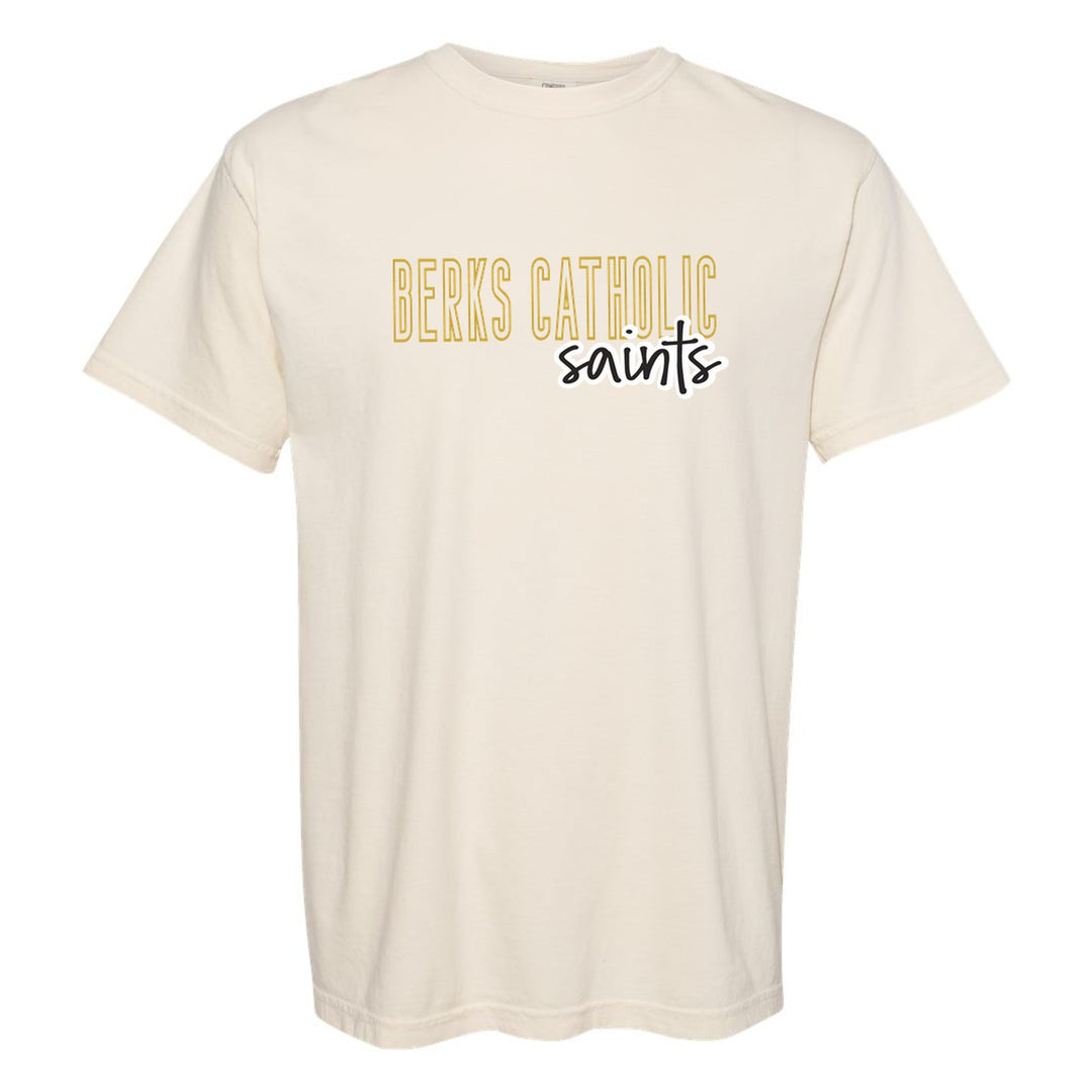 Berks Catholic Saints Outline Script comfort colors t-shirt in Ivory: outlined BERKS CATHOLIC letters with saints script across the front