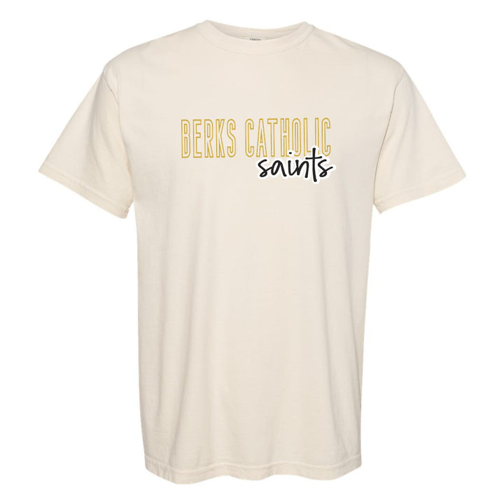 Berks Catholic Saints Outline Script comfort colors t-shirt in Ivory: outlined BERKS CATHOLIC letters with saints script across the front