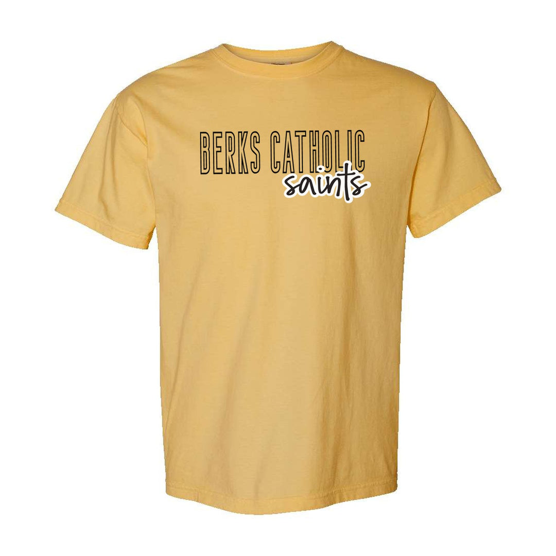 Berks Catholic Saints Outline Script comfort colors t-shirt in Mustard: outlined BERKS CATHOLIC letters with saints script across the front