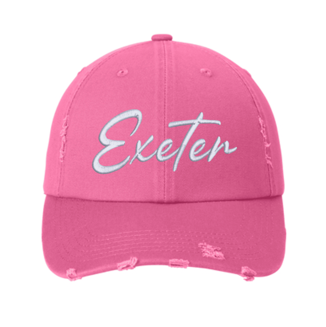 True Pink District distressed dad hat with frayed crown seams and visor edge, embroidered with Exeter in white script across the front