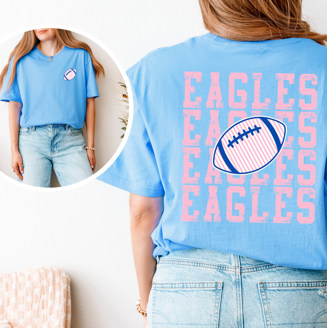 Light blue football t-shirt shown front and back: small pink and navy striped football on the left chest, and EAGLES stacked four times in pink across the back with a striped football through the center