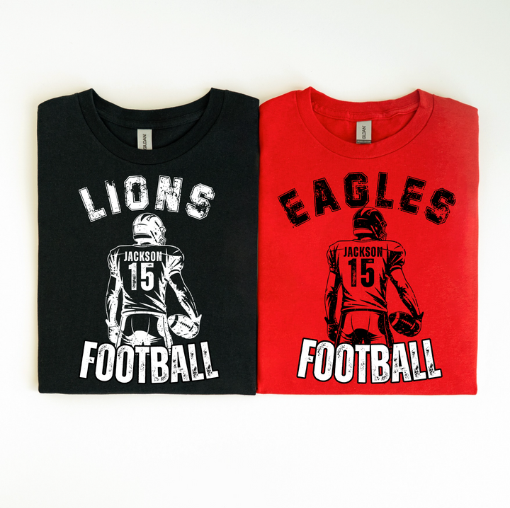 Personalized football t-shirts laid flat: black Lions tee and red Eagles tee, both printed with player name Jackson and number 15