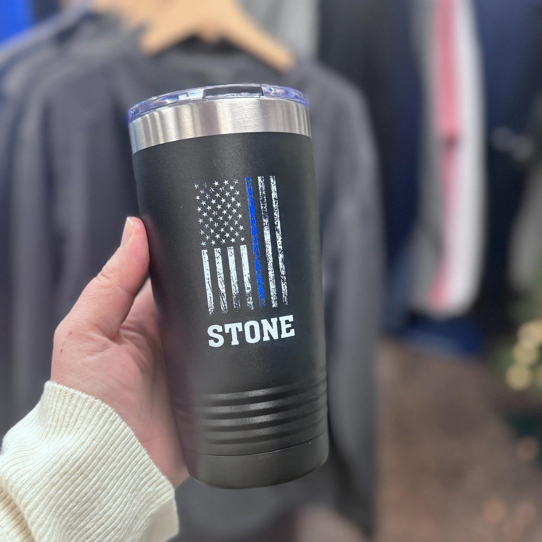 Black tumbler printed with the Thin Blue Line flag and a name, held in hand