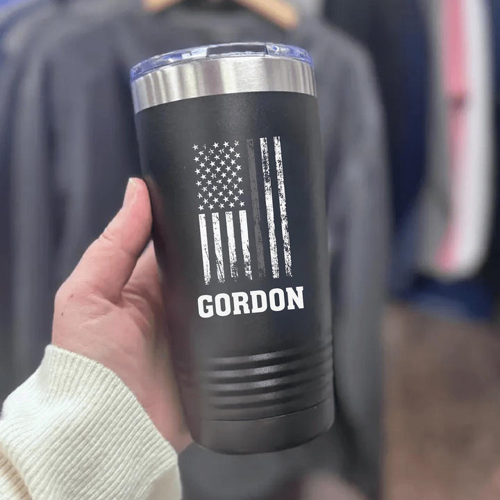 Black 20oz corrections officer tumbler printed in white with a distressed American flag, a grey line stripe and the name GORDON